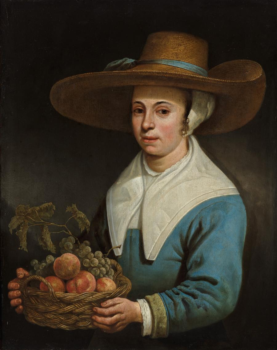 Vrouw met grote strohoed en mand met fruit